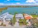 Breathtaking aerial shot of waterfront home showcasing its prime location near bay and lush tropical landscaping at 931 Inlet Cir, Venice, FL 34285