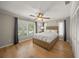 Well-lit bedroom with wood floors, ceiling fan, plantation shutters, and a large closet at 931 Inlet Cir, Venice, FL 34285