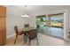 Dining area with sliding glass doors leading to an outdoor seating area and waterfront views at 931 Inlet Cir, Venice, FL 34285
