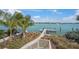 Waterfront property featuring private dock, lush landscaping, and stunning water views under a bright blue sky at 931 Inlet Cir, Venice, FL 34285