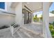 Elegant entryway featuring travertine steps, a covered porch, and stylish double front doors at 931 Inlet Cir, Venice, FL 34285