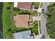 Aerial view of a private home with screened porch, lush backyard, and mature trees at 9528 Knightsbridge Cir, Sarasota, FL 34238
