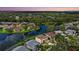 Aerial view of the real estate showcasing a lake surrounded by lush greenery and homes at 9528 Knightsbridge Cir, Sarasota, FL 34238