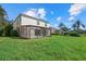 Exterior view of the home showcasing a screened-in porch and a large yard with lush green grass at 9528 Knightsbridge Cir, Sarasota, FL 34238