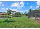 Scenic backyard view with a lush green lawn and a tranquil pond, complete with screened-in patio at 9528 Knightsbridge Cir, Sarasota, FL 34238