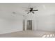 This bedroom features neutral carpet, a ceiling fan, and double doors to another area at 9528 Knightsbridge Cir, Sarasota, FL 34238