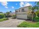 Inviting home featuring a large garage, well-manicured lawn, and beautiful palm trees at 9528 Knightsbridge Cir, Sarasota, FL 34238