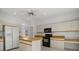 Well-maintained kitchen with white cabinets, black appliances, and an island at 9528 Knightsbridge Cir, Sarasota, FL 34238