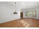 Bright living room with hardwood floors, large windows, and decorative hanging lamp at 9528 Knightsbridge Cir, Sarasota, FL 34238