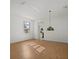 Spacious living room featuring hardwood floors, large windows, and a decorative hanging lamp at 9528 Knightsbridge Cir, Sarasota, FL 34238