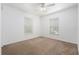 Empty bedroom with carpet flooring, white walls, a ceiling fan, and natural light from two windows at 2397 Morton Rd, North Port, FL 34291