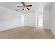 Bright bedroom with a ceiling fan and carpet flooring, leading to other rooms in the house at 2397 Morton Rd, North Port, FL 34291