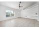Empty room featuring tile floors, neutral paint, and a ceiling fan, with a large window offering ample light at 2397 Morton Rd, North Port, FL 34291