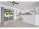 Bright kitchen with white cabinets, tiled floor, and access to outdoor patio at 2397 Morton Rd, North Port, FL 34291