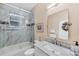 Well-lit bathroom featuring a marble vanity top and tiled shower with a glass door at 102 Bayamo Dr, North Port, FL 34287