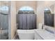 Bathroom featuring a soaking tub, double sink vanity with marble countertop, and a large window at 102 Bayamo Dr, North Port, FL 34287