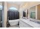 Bathroom showcasing a soaking tub, double sink vanity with marble countertop, and large window at 102 Bayamo Dr, North Port, FL 34287