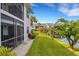 The backyard features lush grass, beautiful flowering trees, and serene views of the pond at 1100 Capri Isles Blvd # 215, Venice, FL 34292