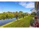 Manicured green lawn overlooking a tranquil pond with lush landscaping and flowering trees at 1100 Capri Isles Blvd # 215, Venice, FL 34292