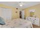 Comfortable bedroom with a ceiling fan, closet, and a view of the hallway to the next room at 1100 Capri Isles Blvd # 215, Venice, FL 34292