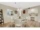 Bright dining space with a glass table, stylish lighting, and a pass-through window to the kitchen area at 1100 Capri Isles Blvd # 215, Venice, FL 34292