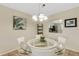 Charming dining area featuring a glass table and chairs beneath a chandelier, adjacent to the kitchen at 1100 Capri Isles Blvd # 215, Venice, FL 34292