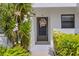Close-up of the condo entrance with a wreath-adorned door and blossoming plants, creating a warm and inviting ambiance at 1100 Capri Isles Blvd # 215, Venice, FL 34292