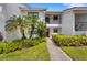 Inviting condo exterior featuring lush landscaping, a private balcony, and a welcoming walkway to the front door at 1100 Capri Isles Blvd # 215, Venice, FL 34292