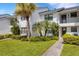 Exterior view of a well maintained condo featuring lush landscaping, inviting walkway and charming curb appeal at 1100 Capri Isles Blvd # 215, Venice, FL 34292