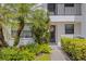 Exterior view of unit 215 with lush landscaping, tropical plants, and a welcoming walkway at 1100 Capri Isles Blvd # 215, Venice, FL 34292