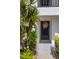 Front door entrance of unit 215 is adorned with a charming wreath and lush tropical landscaping at 1100 Capri Isles Blvd # 215, Venice, FL 34292
