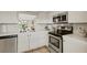 Modern kitchen with stainless steel appliances, white cabinets and ample counter space at 1100 Capri Isles Blvd # 215, Venice, FL 34292