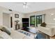 Living room with a ceiling fan, and sliding glass doors to an outdoor patio and comfortable seating arrangements at 1100 Capri Isles Blvd # 215, Venice, FL 34292