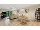 Open-concept living and dining area with a neutral color palette, tile flooring, and sliding doors to outdoor patio at 1100 Capri Isles Blvd # 215, Venice, FL 34292