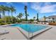 Community pool surrounded by palm trees, lounge chairs, and lush landscaping at 1100 Capri Isles Blvd # 215, Venice, FL 34292