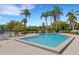 Community pool surrounded by palm trees, lounge chairs, and lush landscaping at 1100 Capri Isles Blvd # 215, Venice, FL 34292