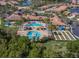 Stunning aerial view of the community clubhouse, featuring multiple pools, lush landscaping, and recreational areas at 11192 Campazzo Dr, Venice, FL 34292