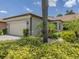 Single-story home with a tile roof, two-car garage, and attractive landscaping at 11192 Campazzo Dr, Venice, FL 34292