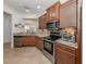 Spacious kitchen with stainless steel appliances, granite countertops, tile floors, and wooden cabinetry at 11192 Campazzo Dr, Venice, FL 34292