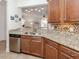Modern kitchen features stainless steel appliances, granite countertops, and wooden cabinets at 11192 Campazzo Dr, Venice, FL 34292