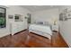 Serene bedroom with hardwood floors, natural light, and a large dresser with mirror at 11192 Campazzo Dr, Venice, FL 34292