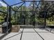 This covered and screened-in patio features brick flooring and views of the backyard at 11192 Campazzo Dr, Venice, FL 34292