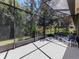 Screened-in patio with brick flooring and outdoor seating overlooks lush landscaping and trees at 11192 Campazzo Dr, Venice, FL 34292
