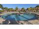 Large community pool with palm trees, lounge chairs and covered seating areas, perfect for relaxation at 11192 Campazzo Dr, Venice, FL 34292