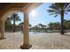 Tranquil pool area with inviting seating and the sun shining through palm trees on a clear day at 11192 Campazzo Dr, Venice, FL 34292