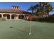 Well-manicured putting green in a community with inviting landscaping and a clubhouse on a clear day at 11192 Campazzo Dr, Venice, FL 34292