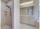 Bright bathroom featuring a tiled shower with unique fixtures, large vanity, and marble accents at 1136 Deardon Dr, Venice, FL 34292