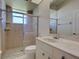 This bathroom features a large shower with glass doors, large vanity, and tile flooring at 1136 Deardon Dr, Venice, FL 34292