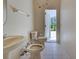 This bathroom features a pedestal sink, toilet, and bidet with white tiling and access to the outdoors at 1136 Deardon Dr, Venice, FL 34292