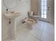 This bathroom features a pedestal sink, toilet, and bidet with white tiling and access to the outdoors at 1136 Deardon Dr, Venice, FL 34292